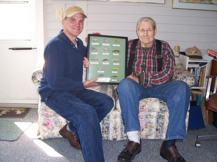 Ken Craigue Jr. presenting Jim Warner with a framed set of streamers from the Jim Warner Fly Swap